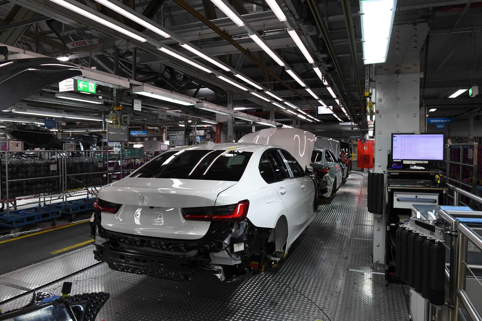 New cars stand at an assembly line in the main company of Germany's carmaker BMW in Munich, southern Germany, on October 22, 2021. (Photo by Christof STACHE / AFP)