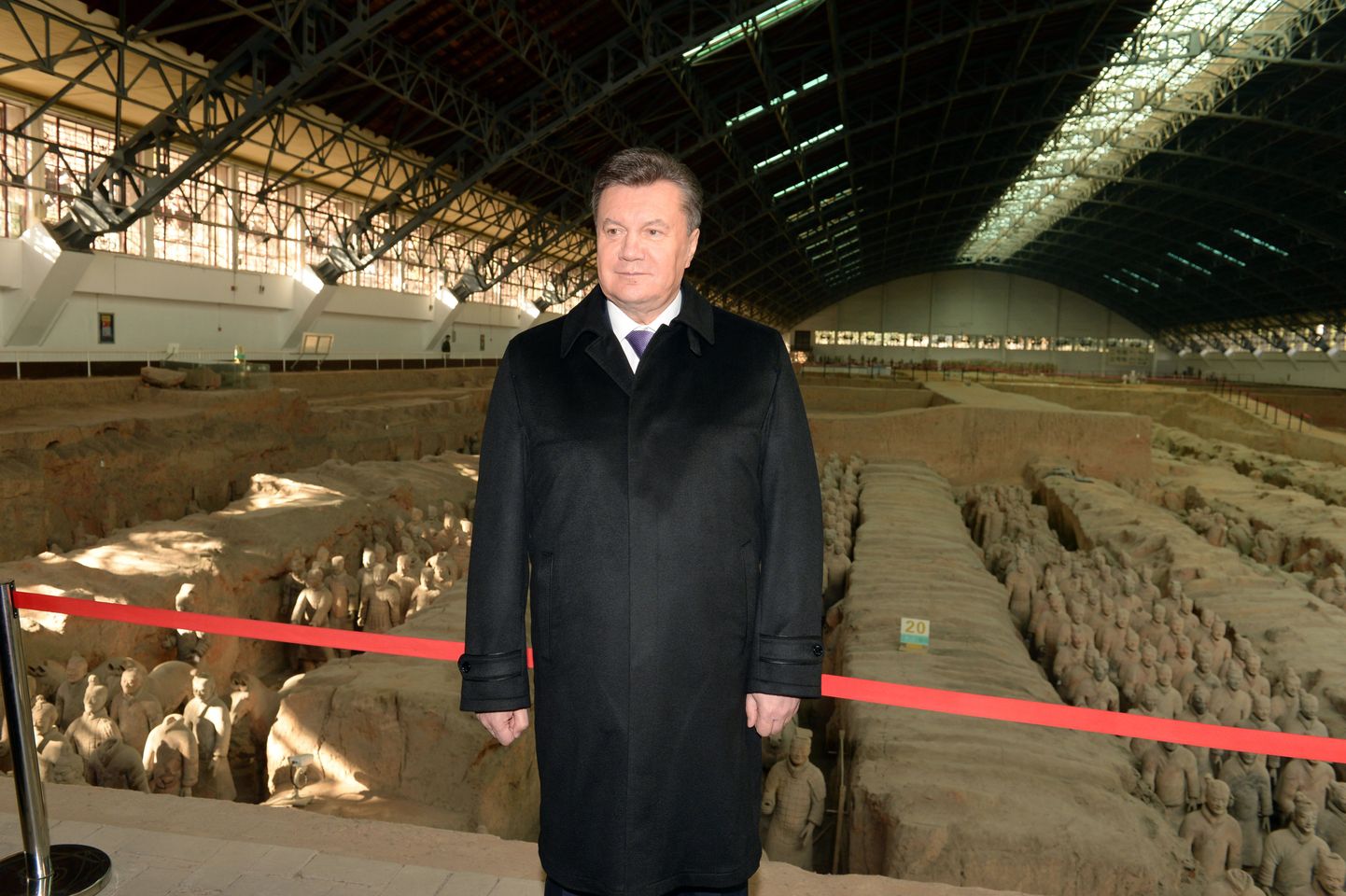 Ukraine's President Viktor Yanukovych poses for a photo before the life-sized sculptures of warriors in Xian, northwest China's Shanxi province on December 4, 2013. Viktor Yanukovych visited China's Terracotta Warriors on December 4, officials said, a respite from street protests at home calling for his resignation.      CHINA OUT  AFP PHOTO