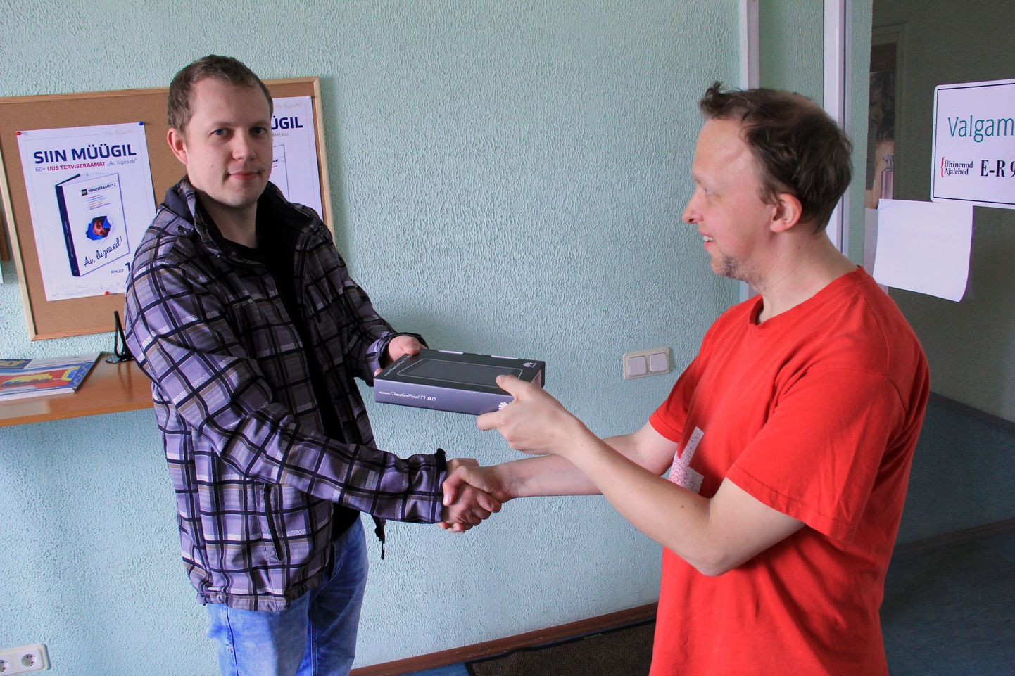 Ivo Grant (vasakul) saab tahvelarvuti kätte Valgamaalase tegevtoimetajalt Jaan Rapilt.