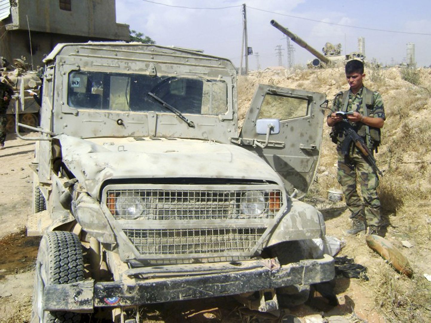 Süüria sõdur seisab väidetavalt Iisraeli päritolu militaarsõiduki juures. Valitsusvägede kinnitusel oli see olnud Süüria mässuliste käsutuses.