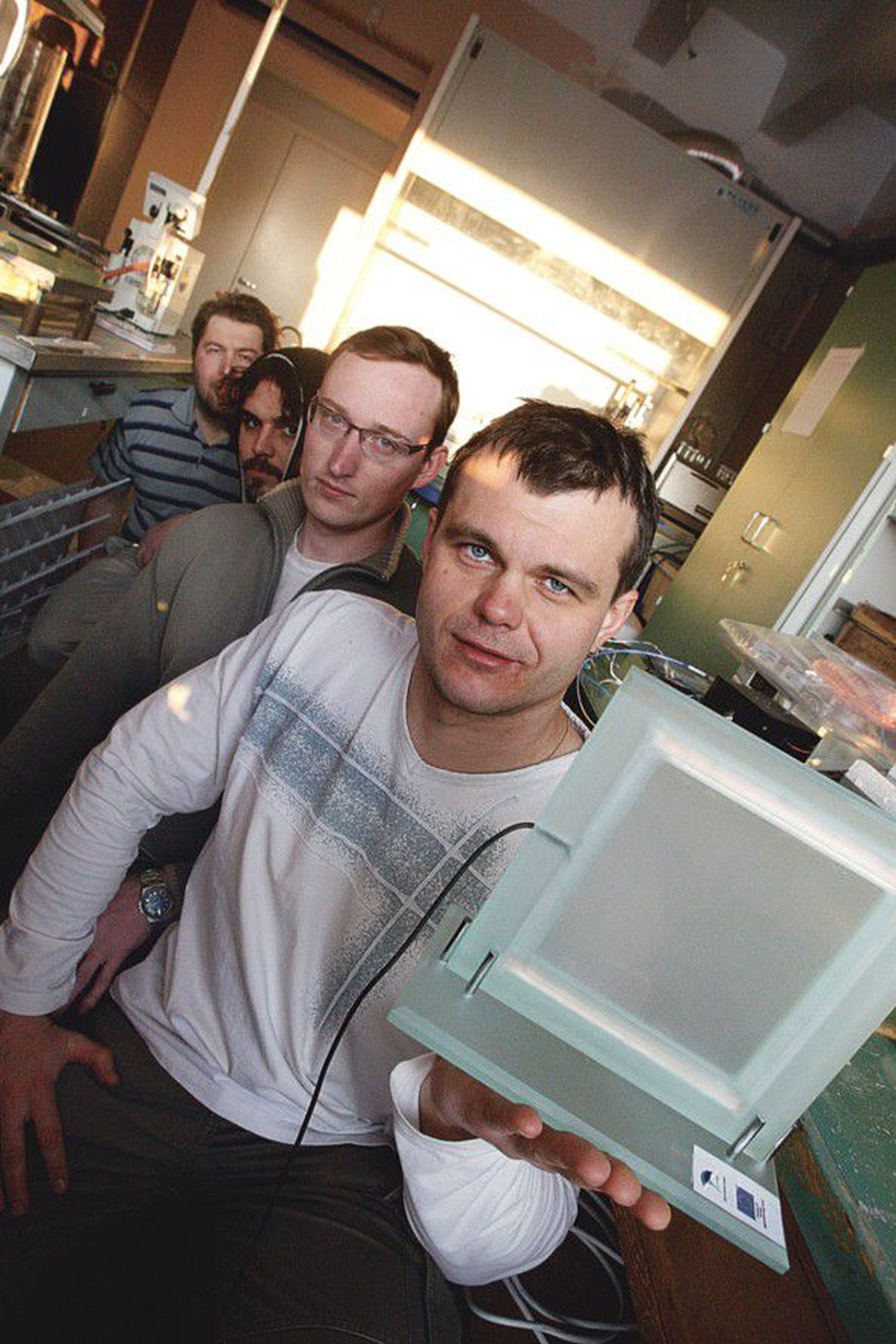 Ученые Института физики Тартуского университета и Nano TAK Кристьян Саал (справа налево), Мартин Тимуск, Мартин Ярвекюльг и Рюнно Лыхмус демонстрируют электрооптическое стекло.
