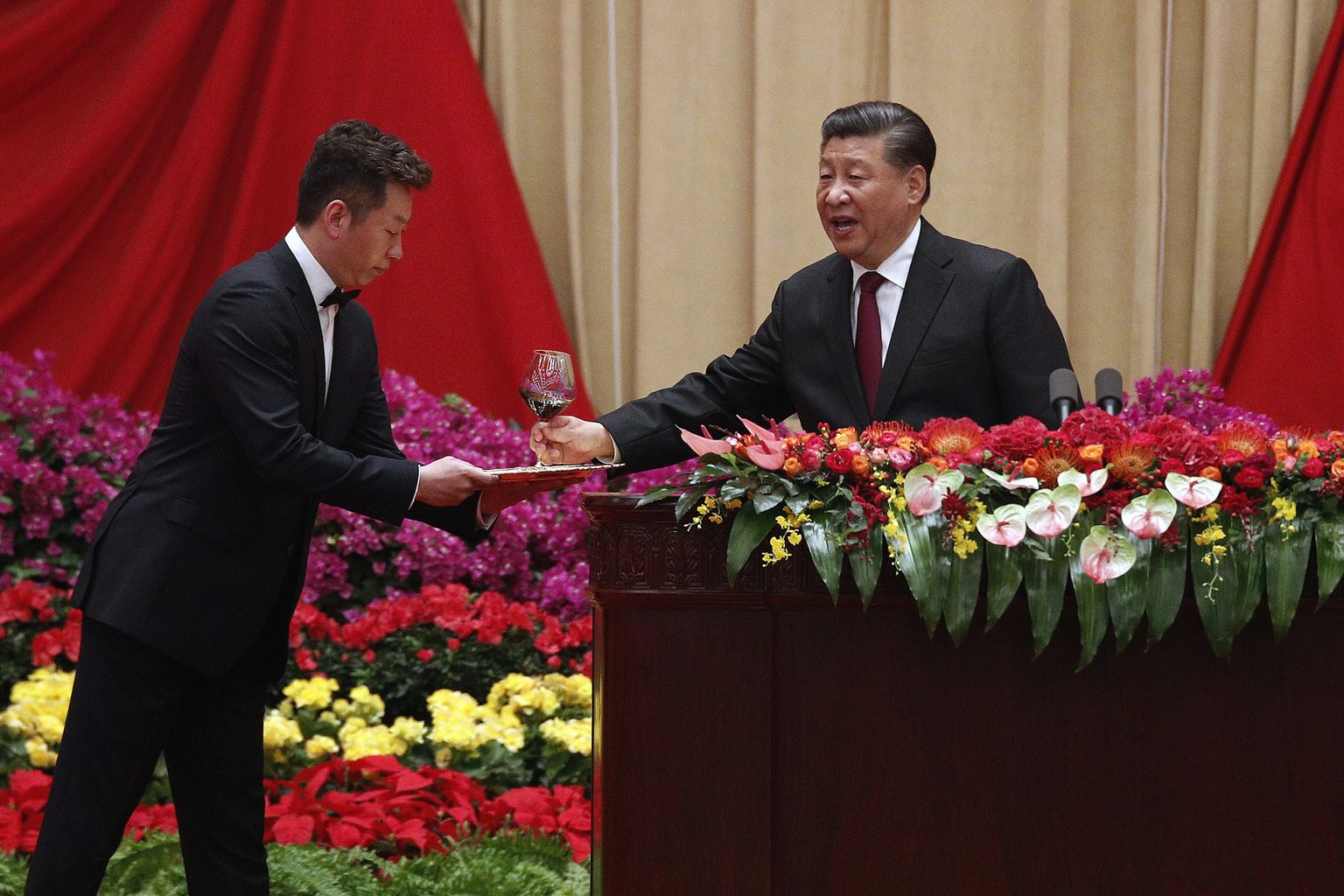 Hiina president Xi Jinping esmaspäeval Hiina rahvavabariigi asutamise 70. aastapäeva eelõhtul Pekingi Suures rahvapalees pidulikul õhtusöögil enne kõnet veiniklaasi võtmas.