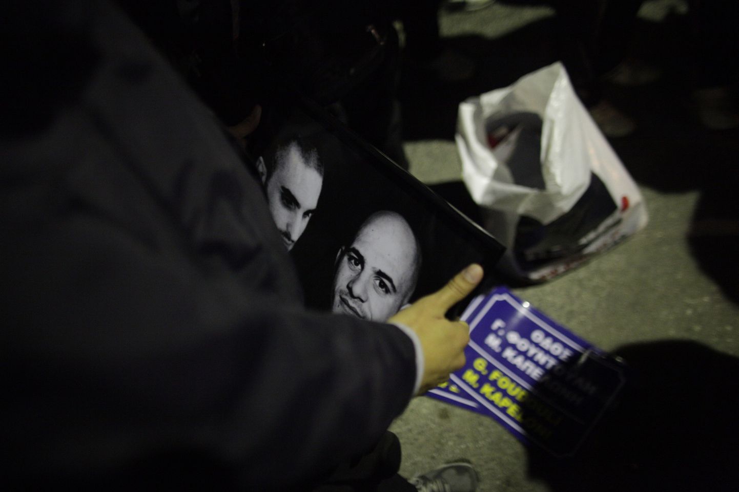 Kuldse Koidiku toetaja hoiab käes kahe tapetud parteiliikme Manolis Kapelonise ja Giorgos Foudoulakise pilte.