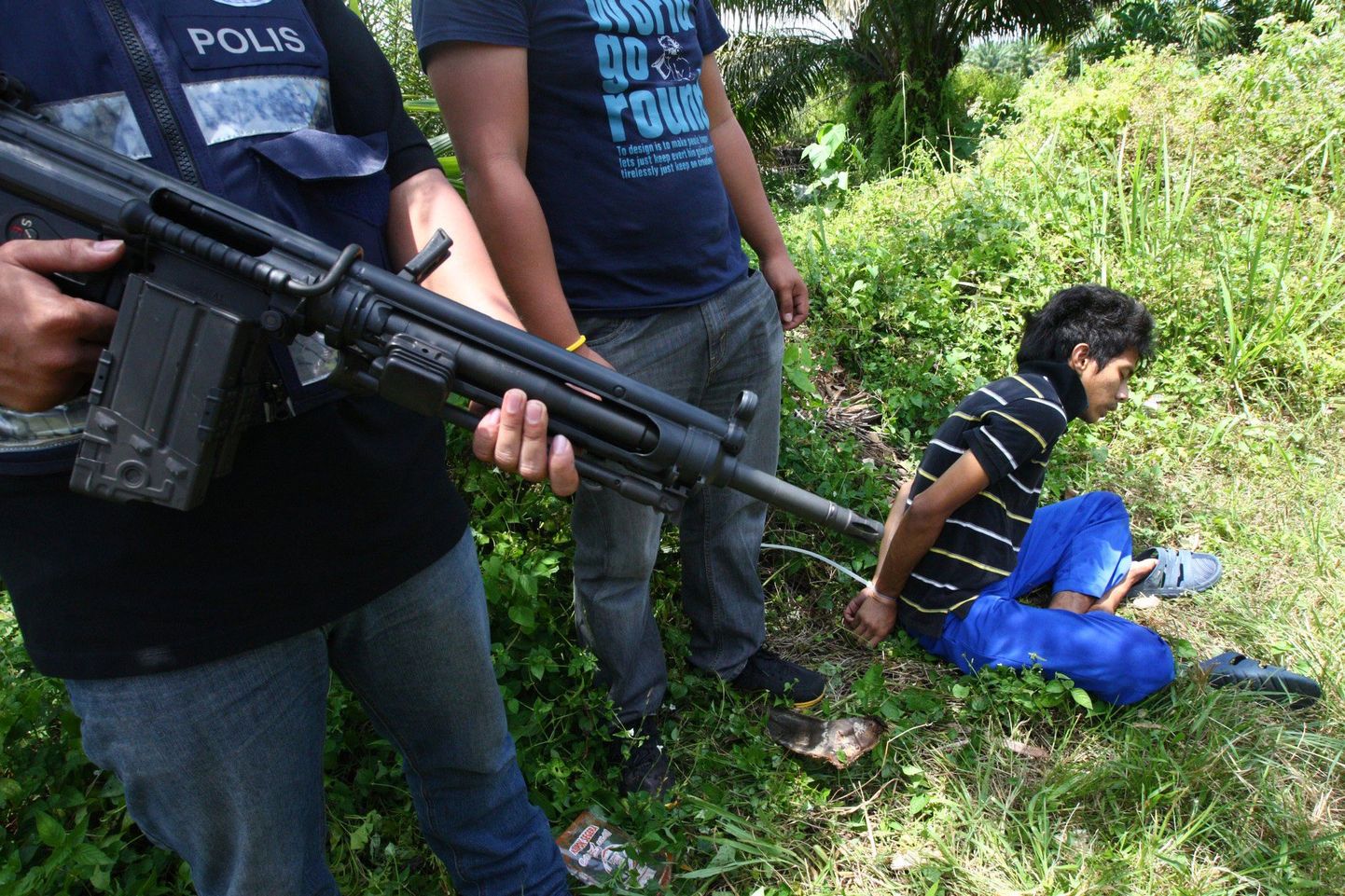 Malaisia politseinikud valvavad arvatavat filipiinlasest sissetungijat, kes koos mõttekaaslastega veebruaris Borneo saarele sisse tungisid.
