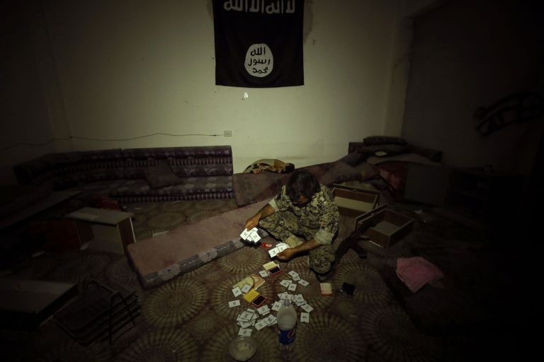 Süüria Demokraatlike Relvajõudude võitleja uurib Islamiriigi võitlejatest maha jäänud esemeid.