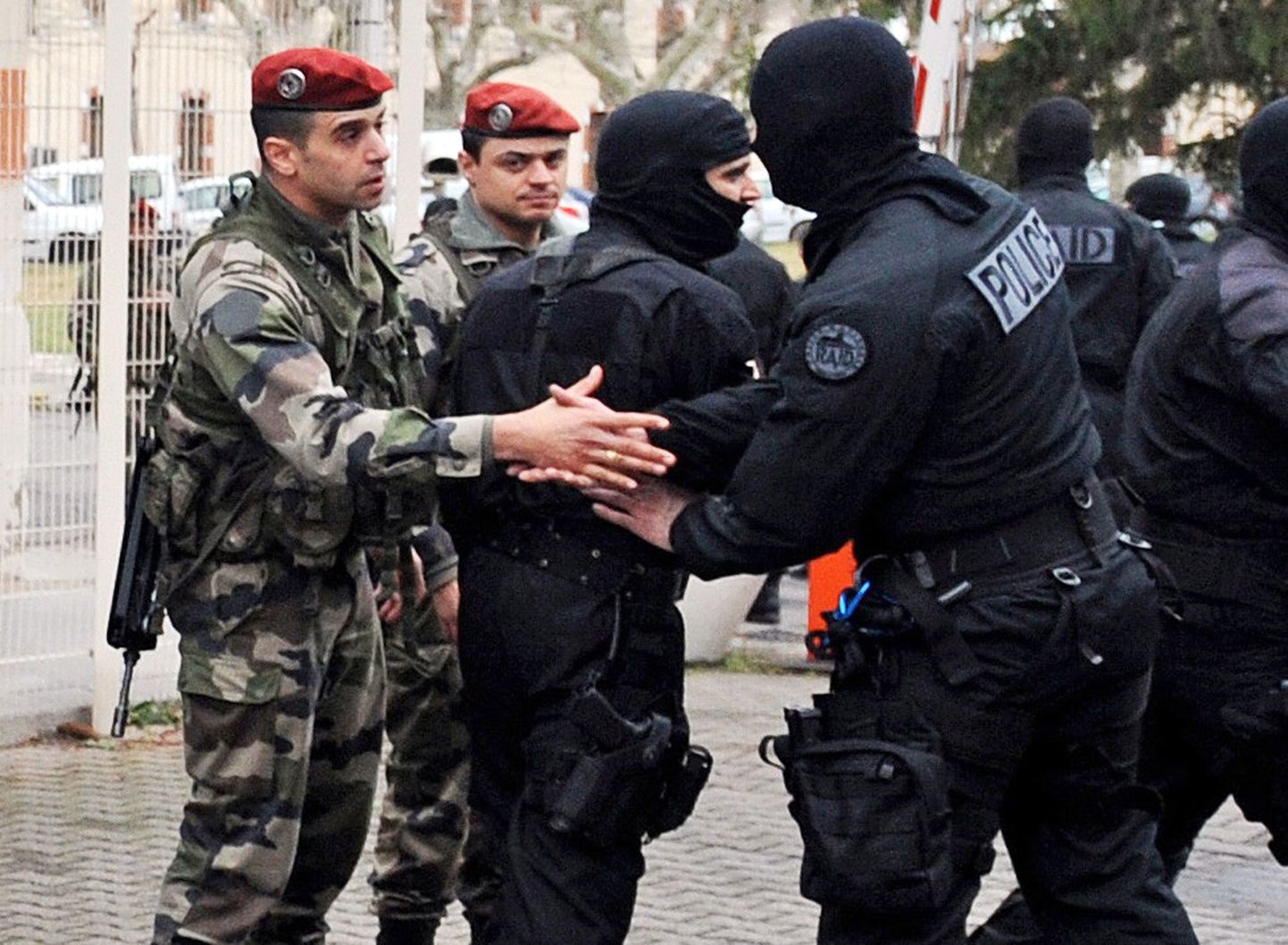 Prantsuse politsei ja sõjaväe eriüksuslased pärast operatsiooni üksteisel kätt surumas.