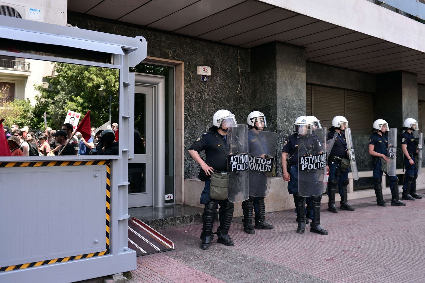 Politseinikud turvamas Euroopa Liidu Ateena-esindust taas Kreeka pealinnas lahvatanud protsestimarsside ajal.