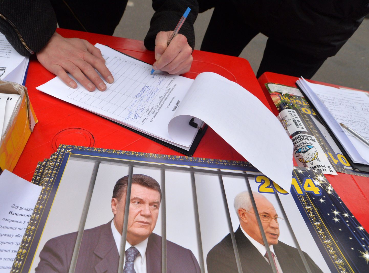 Mees allkirjastab poliitilist petitsiooni, millega nõutakse  president Viktor Janukovõtsi ja peaminister Azarovi tagasiastumist. Foto tehti täna Iseseisvuse väljakul Kiievis.