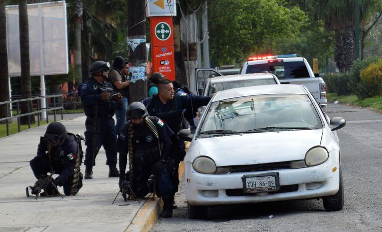 Politseinikud varjumas auto taha. Foto: Stringer/Scanpix