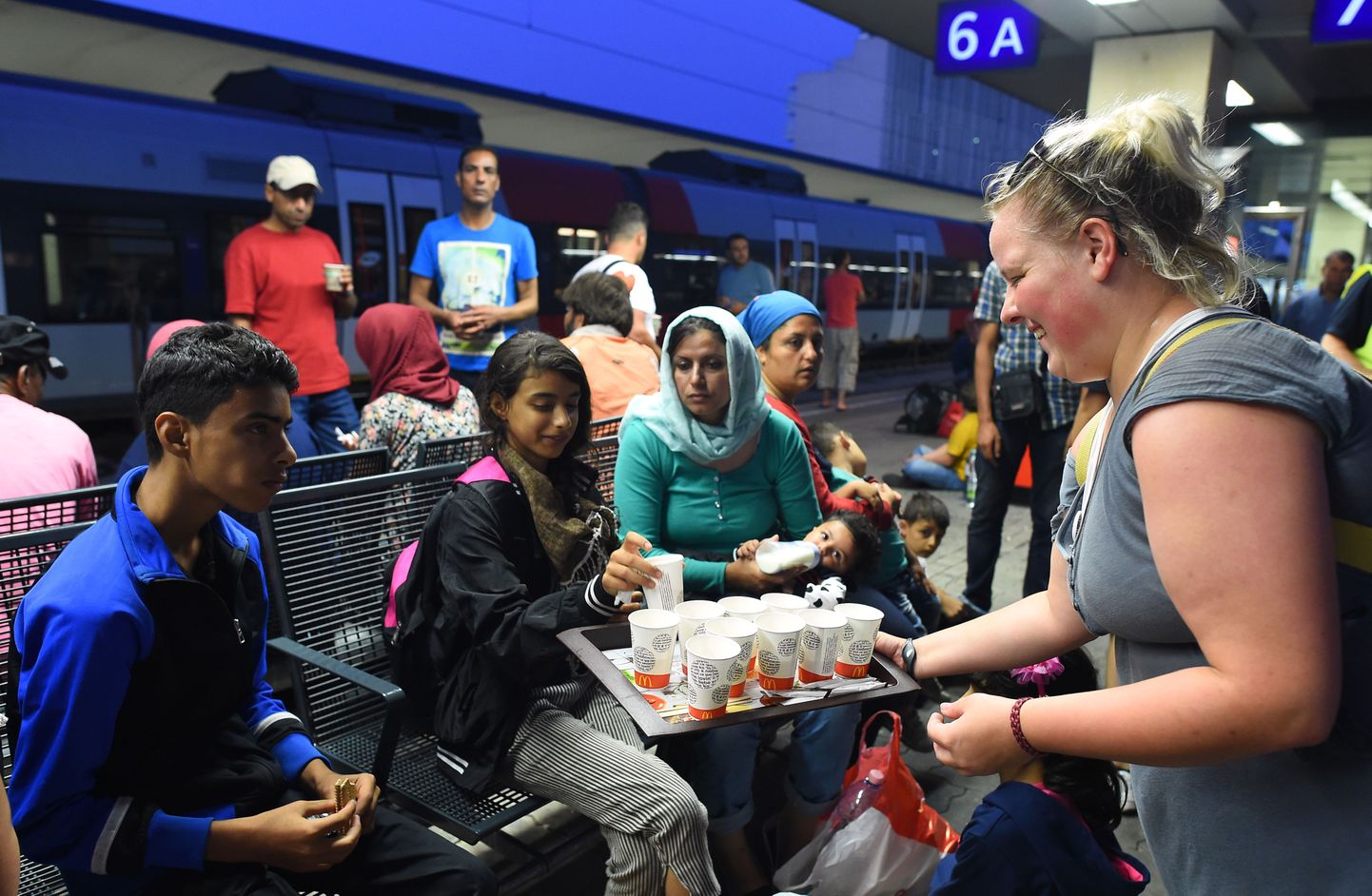 Austria vabatahtlik täna Viini Westbahnhofis saabunud pagulastele juua pakkumas.