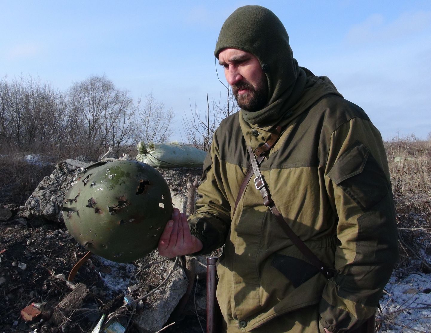 «Donetski rahvavabariigi» nimel võitlev mees uurib Ozerjanovkast leitud kiivrit.