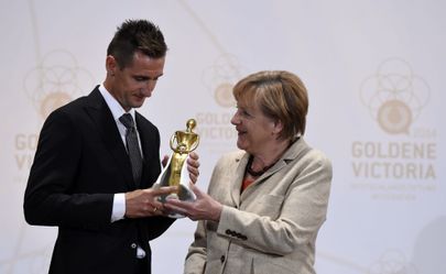 Saksamaa liidukantsler Angela Merkel annab Kuldse Victoria auhinna üle Saksa jalgpallurile Miroslav Klosele.