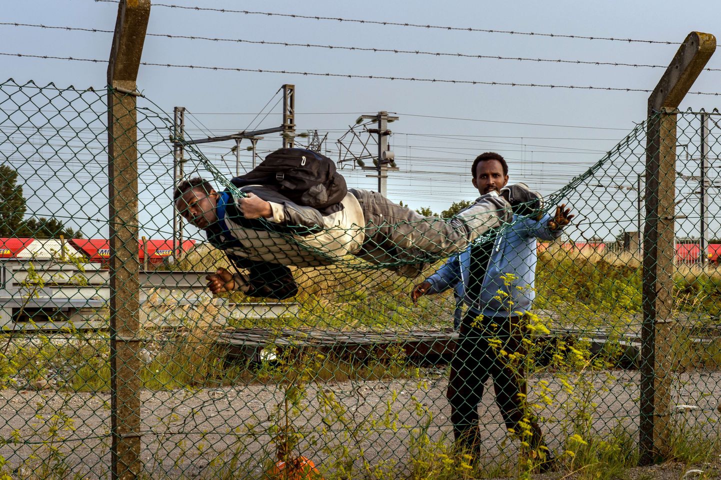 Immigrandid ületamas ebaseaduslikult aeda Calais, pääsemaks Eurotunnelisse.