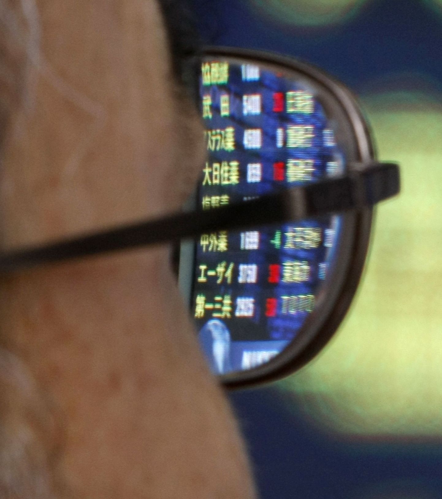 Elektrooniline aktsiahindade tabloo peegeldumas tokiolase prilliklaasilt.