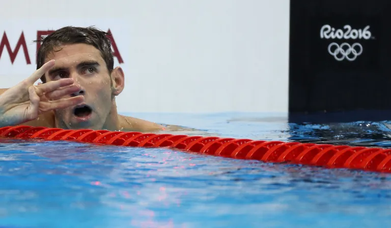 Michael Phelps näitab nelja sõrme - just nii palju kuldmedaleid on ta võitnud Riost. Foto: Reuters