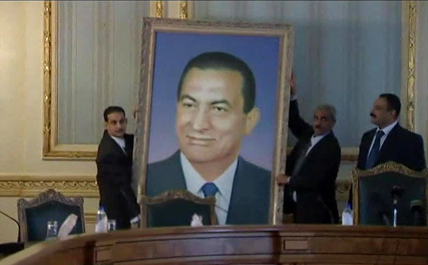 Mehed tõstavad Hosni Mubaraki portree maha tema töökabineti seinalt.