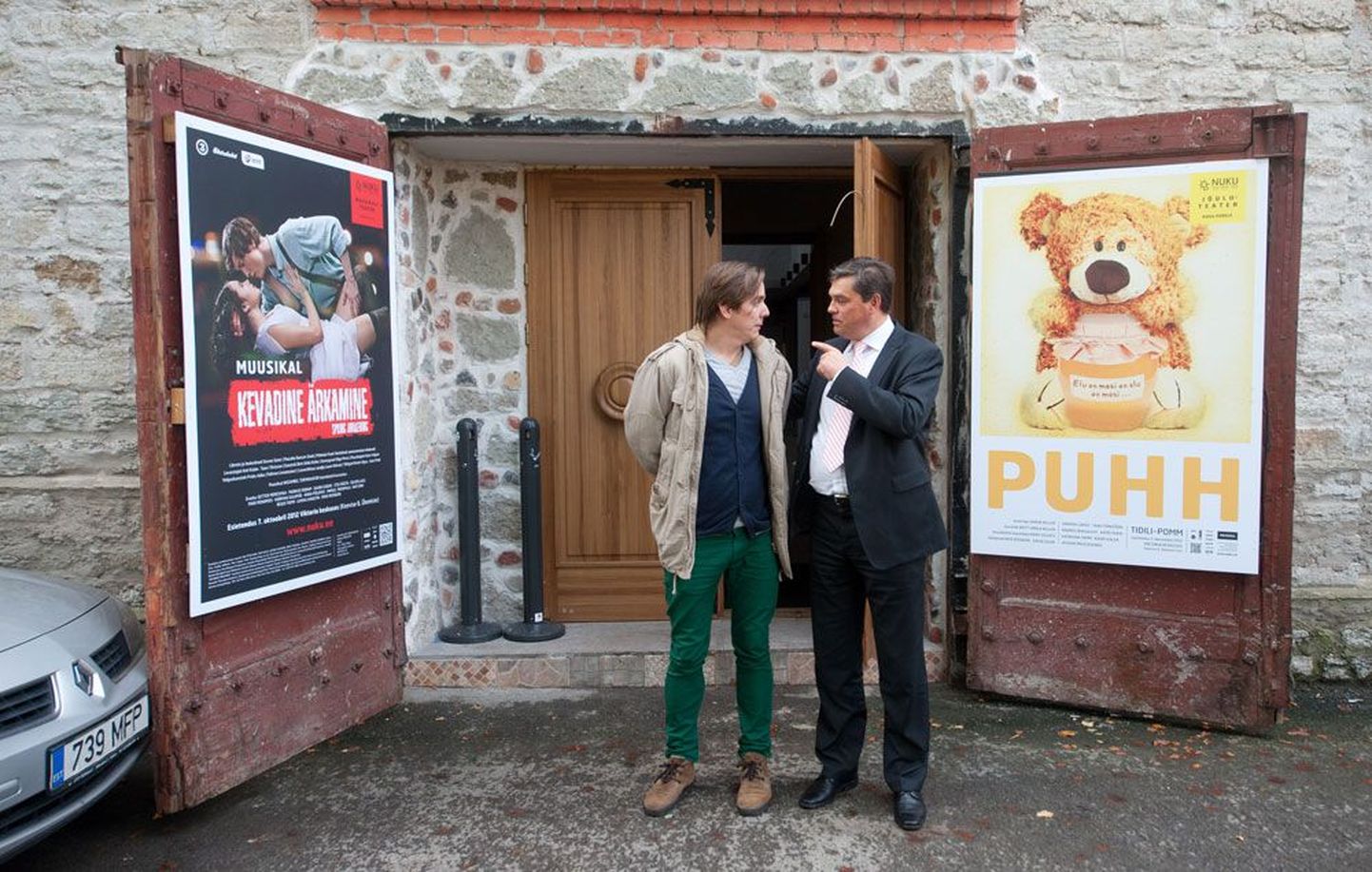 Lavastaja Taavi Tõnisson ja teatrijuht Meelis Pai nukuteatri ajutise suure saali ukse, millel «Puhhi» plakat, ees.