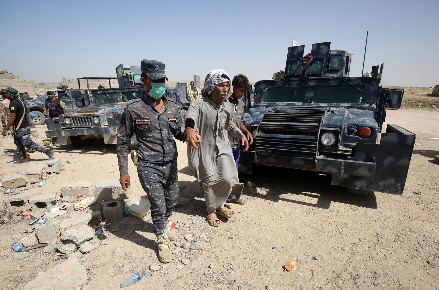 Iraagi valitsusväelased aitamas Fallujah´lähedal asuvast külast põgenenud meest.