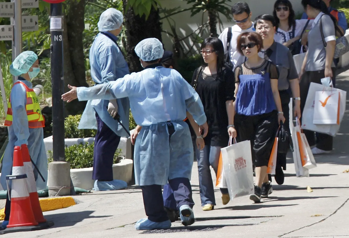 Hongkongi tervishoiutöötajad juhivad puhkuselaagrist välja inimesi, kes olid seal gripiohu tõttu karantiinis.