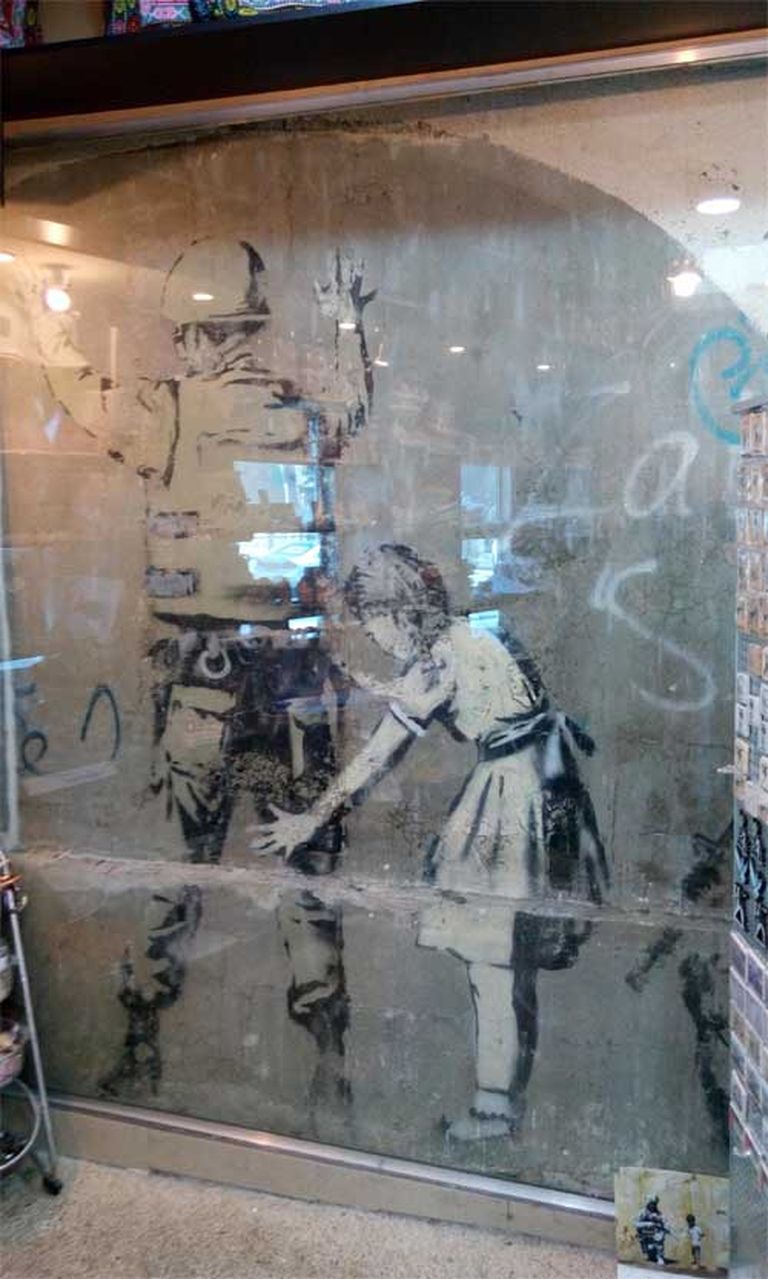 Benksija oriģinālais darbs ar meiteni un karavīru tagad ir aiz stikla, un tam apkārt izveidots suvenīru veikals 