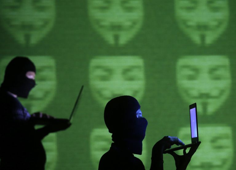 Maskides poseerijad etendavad Anonymuse häkkereid. Foto: Scanpix