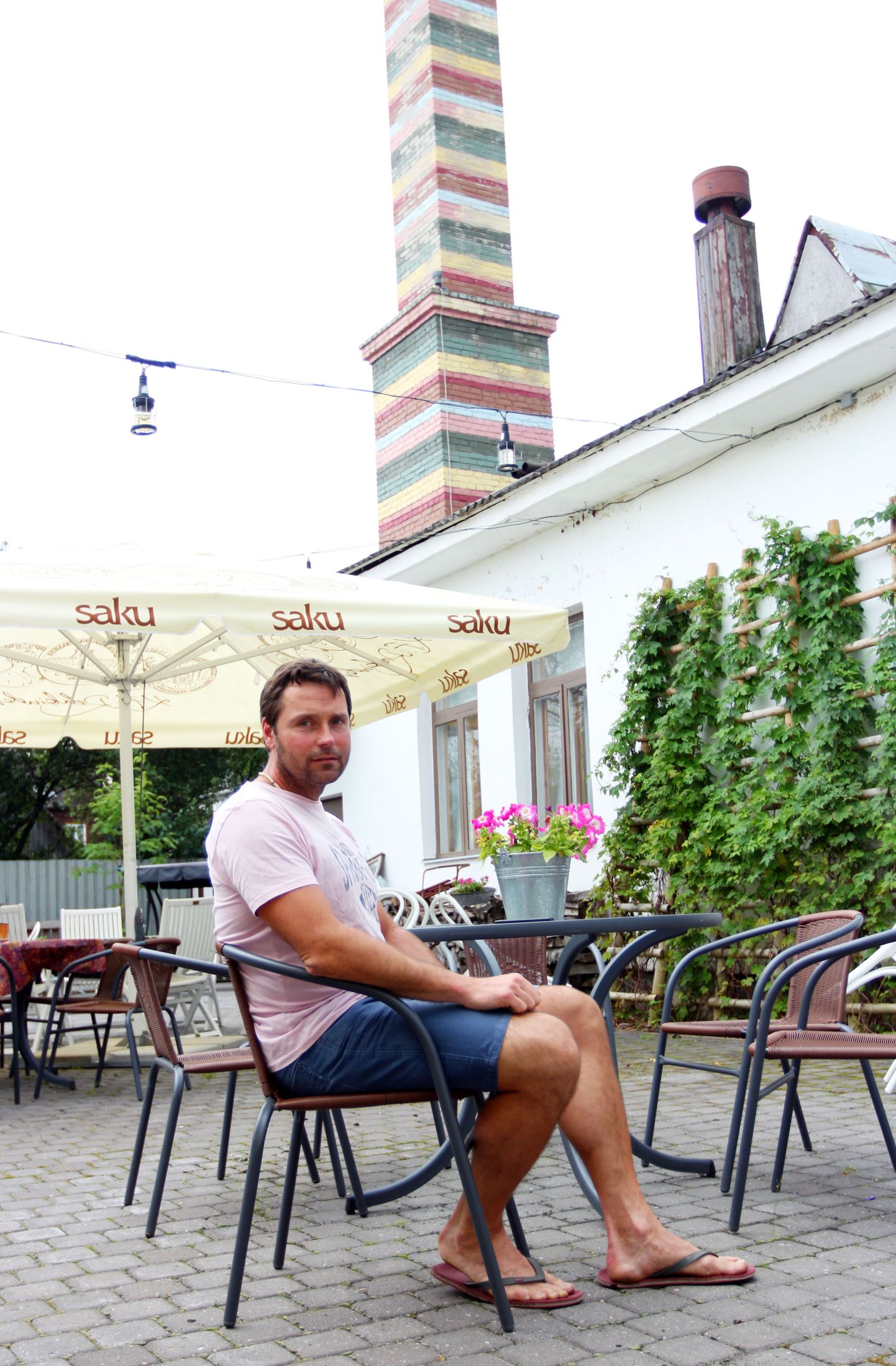 Veikko Täär 2014. aastal oma kohvik-restoranis l.u.m.i Otepää kihelkonna rahvariideseeliku mustrit imiteeriva saunakorstna taustal.