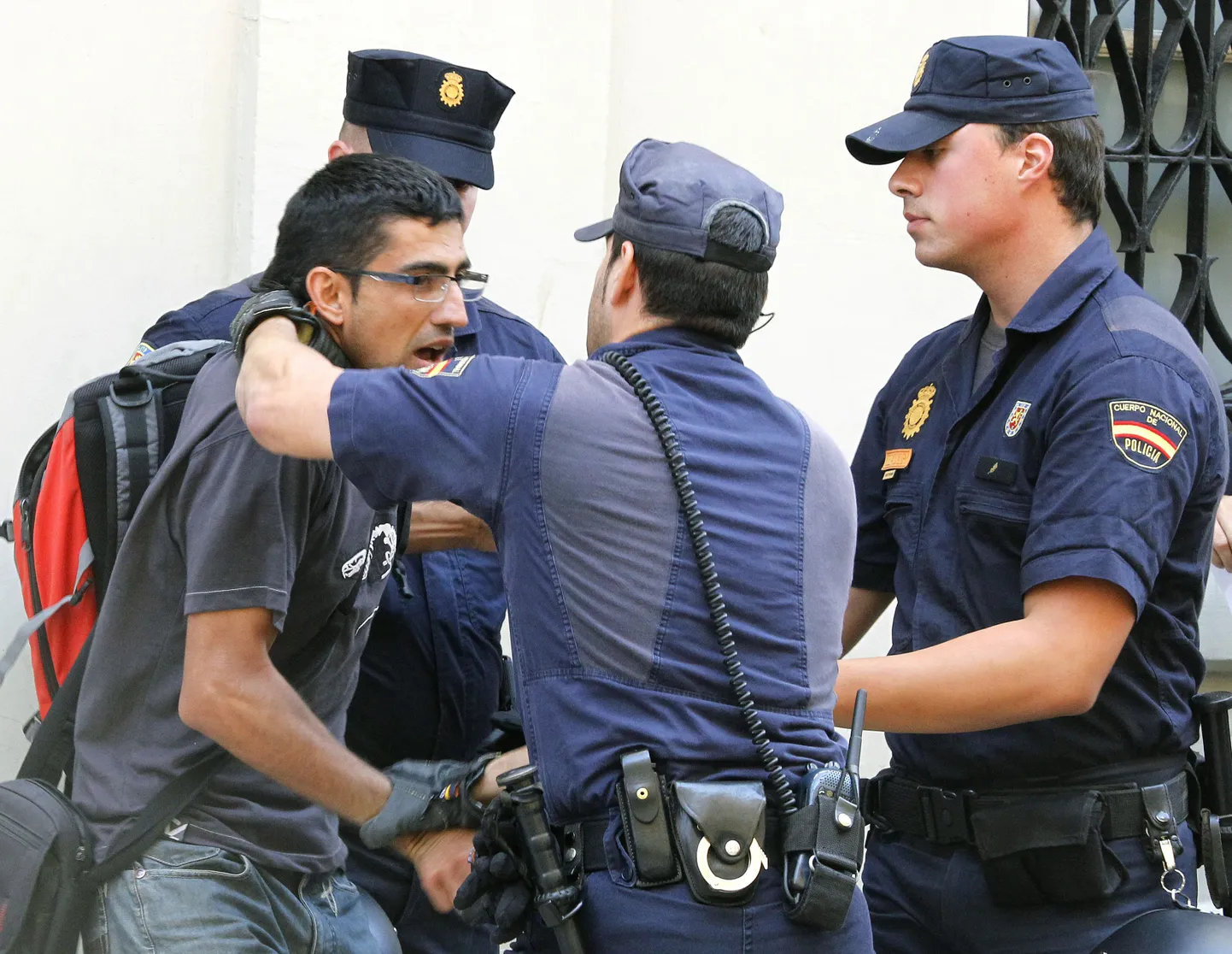 Politseinikud vahistamas meeleavaldajat täna hommikul Valencias.