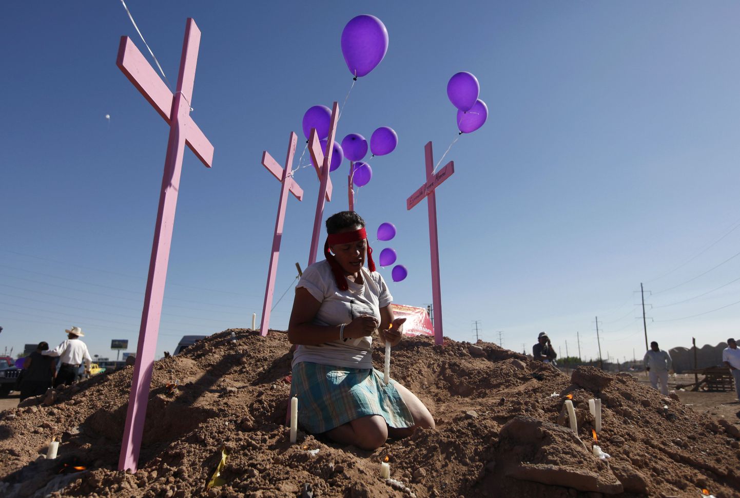 Mehhiklanna palvetab tapetud naiste mälestuseks püstitatud roosade ristide juures.