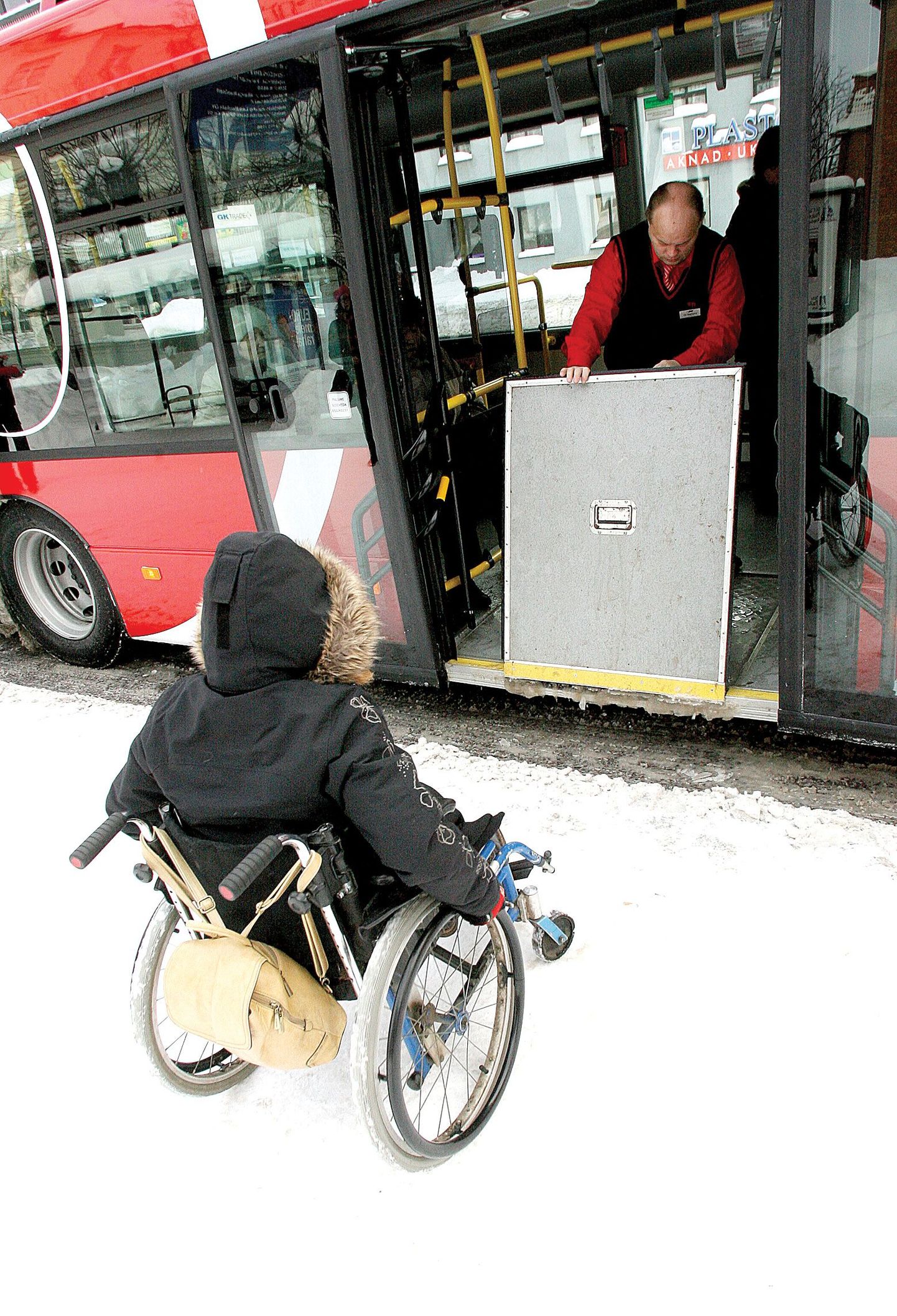 Ave Jaakson ootab ratastoolis, et bussijuht Jüri Riisenberg avaks bussi keskmise ukse juures oleva kaldtee, mis hõlbustab bussile ja bussilt sõitmist.