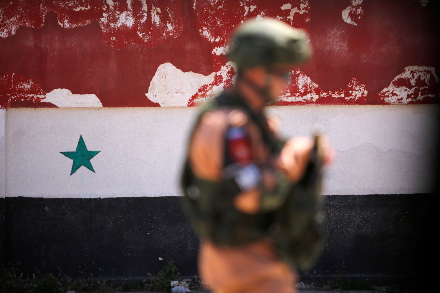 Vene sõdur Süüria lipu taustal Homsis.