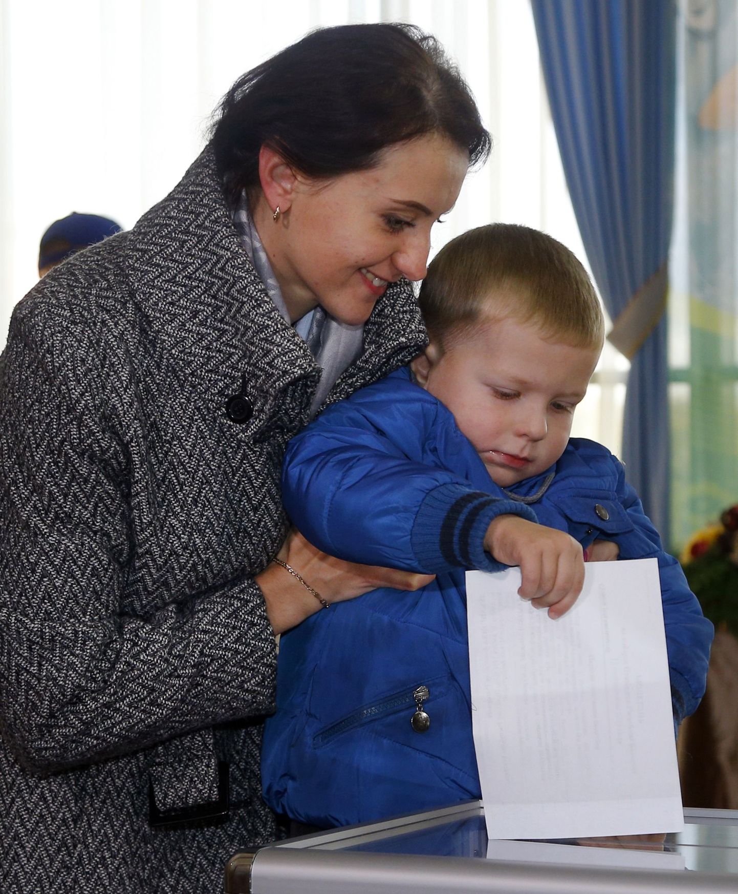 Naine Minskis hääletussedelit kasti lükkamas.