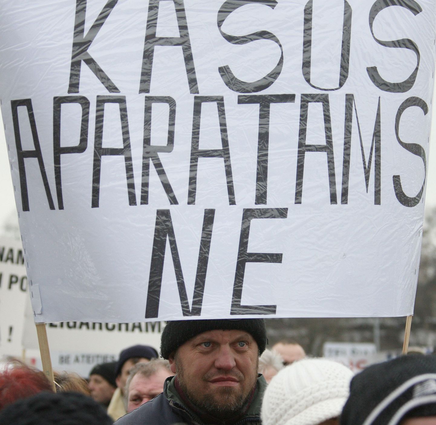 Leedu meeleavaldaja kassaaparaatide vastase plakatiga.