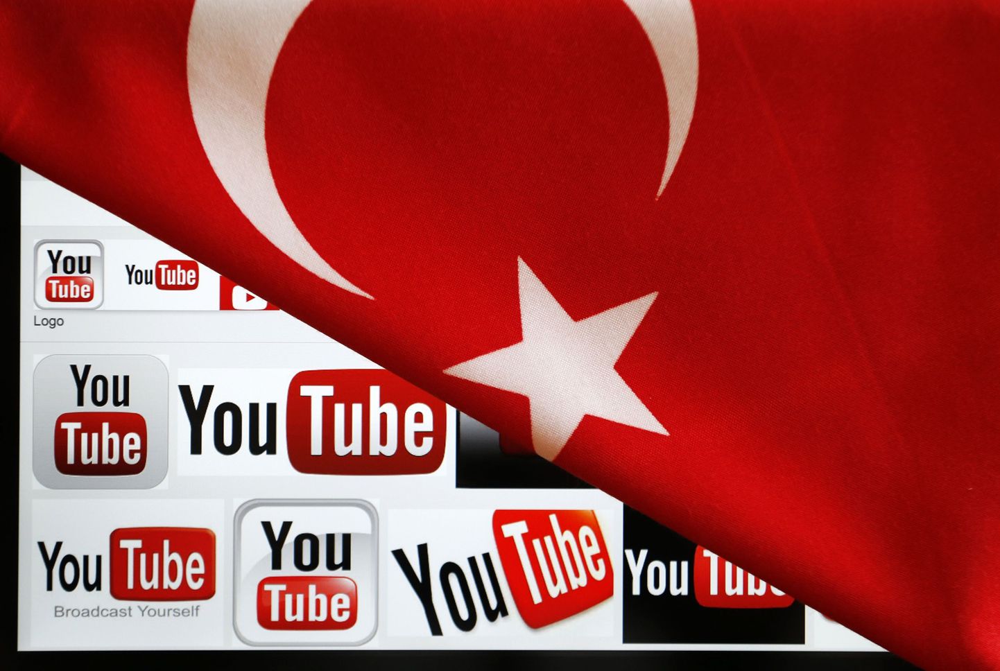 Sülearvuti ekraanil olevad YouTube'i logod on osaliselt kaetud Türgi lipuga.