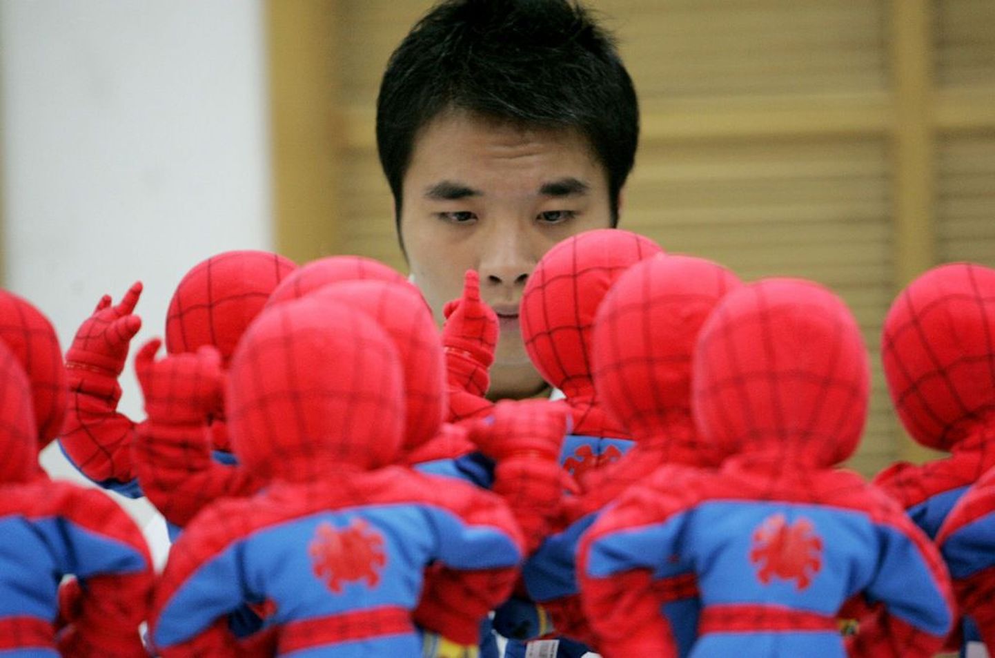 Hiina tööline kontrollimas Ämblikmehe nukke.