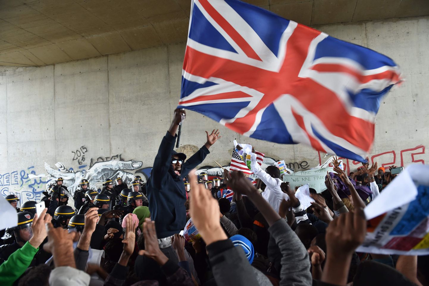 Migrandid lehvitamas meeleavaldusel Suurbritannia lippu.