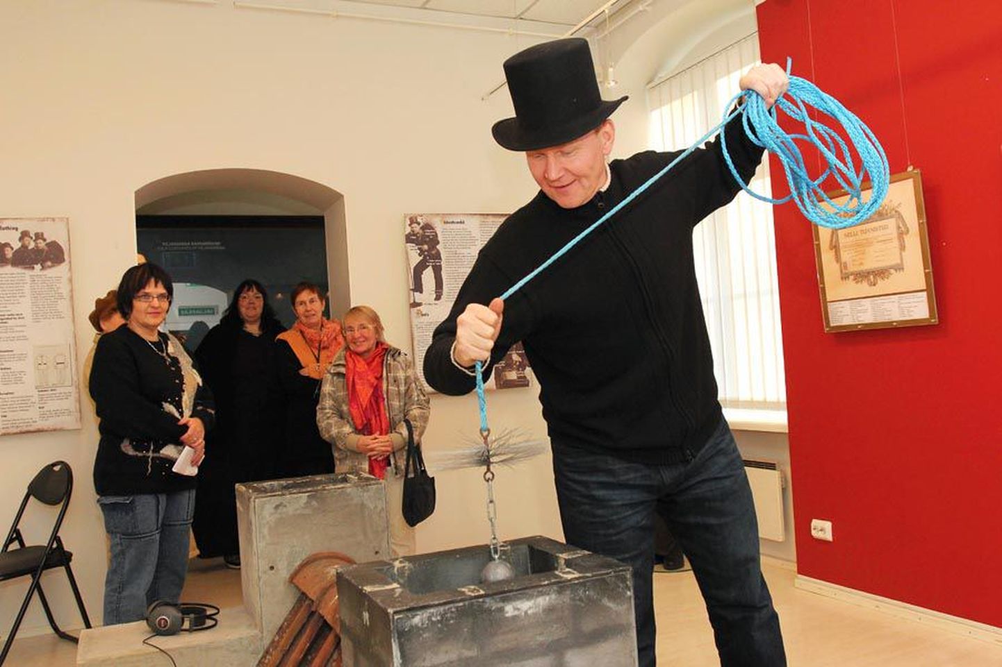 Muuseumi direktor Jaak Pihlak näitab, kuidas korstnapühkijad tööd teevad.