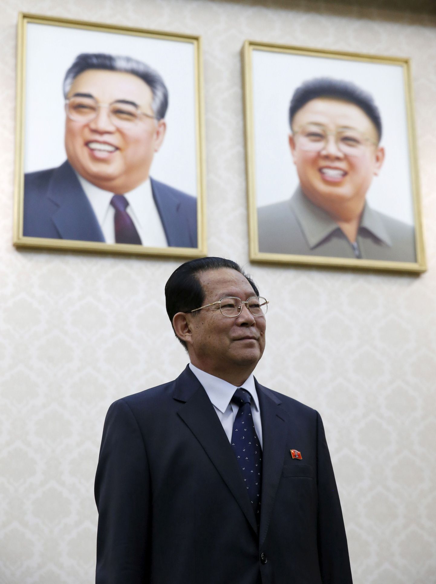 Põhja-Korea saadik Venemaal poseerimas endiste riigijuhtide Kim Il-Sungi (vasakul) ja Kim Jong-ili portreede ees.