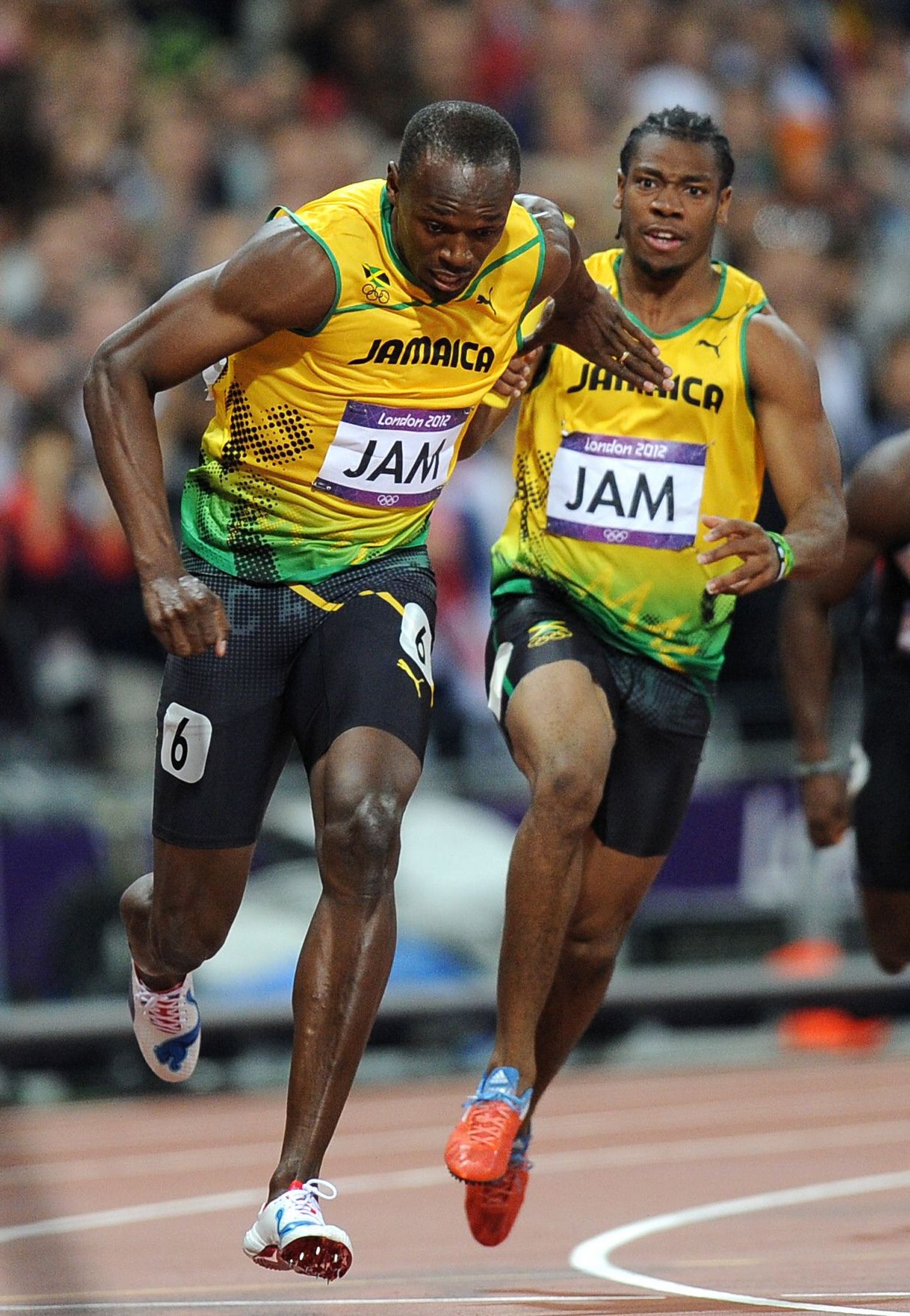 Usain Bolt (vasakul) Londoni OMil Yohan Blake'i käest teatepulka saamas.