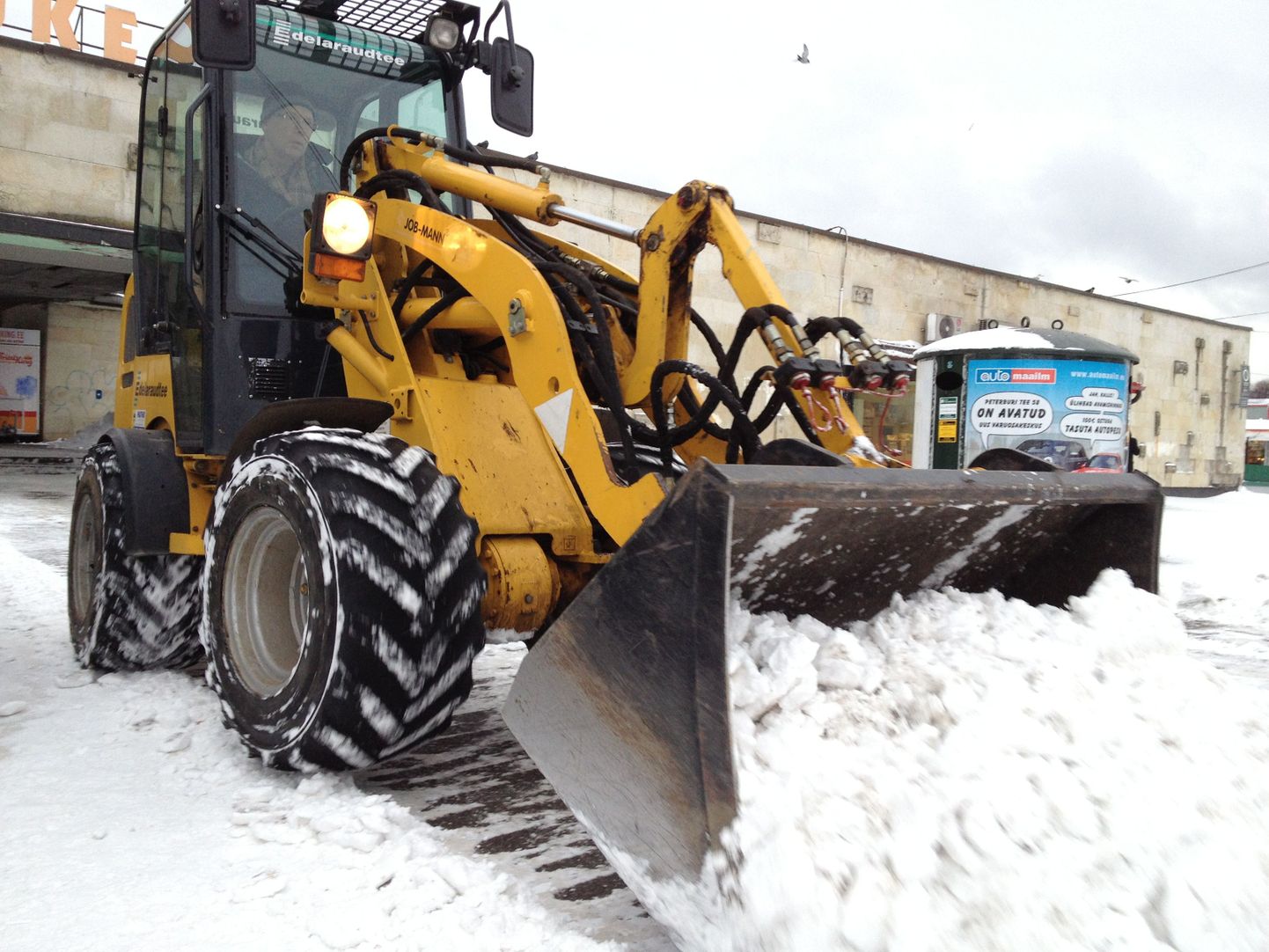 Трактор убирает снег.