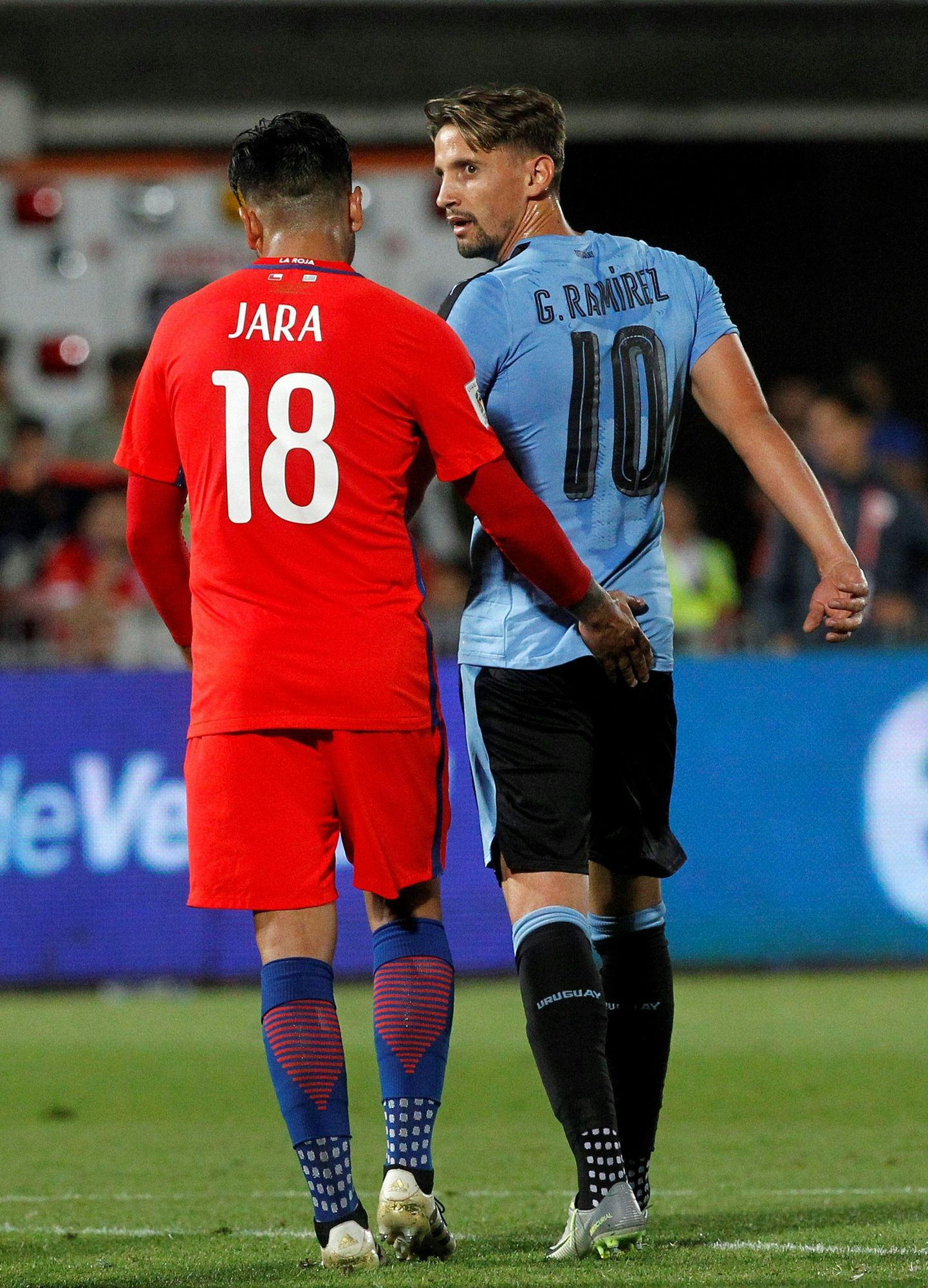 Gonzalo Jara (vasakul) askeldab Uruguay mängumehe Gaston Ramirezi tagumiku kallal.
