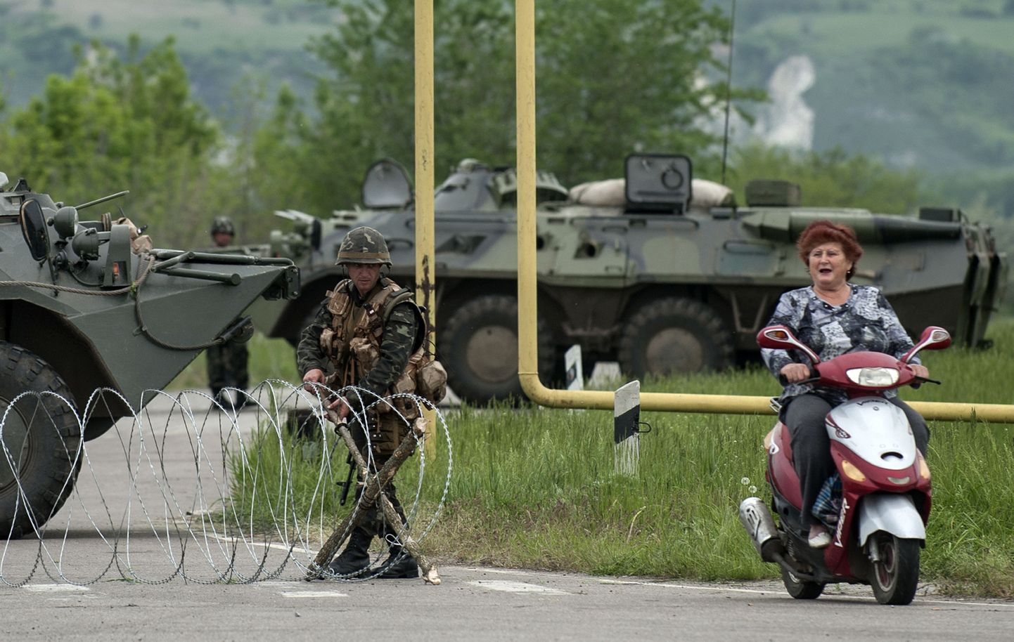 Naine rolleril möödumas Ukraina sõjaväelaste piiripunktist Spivakovka küla lähistel.