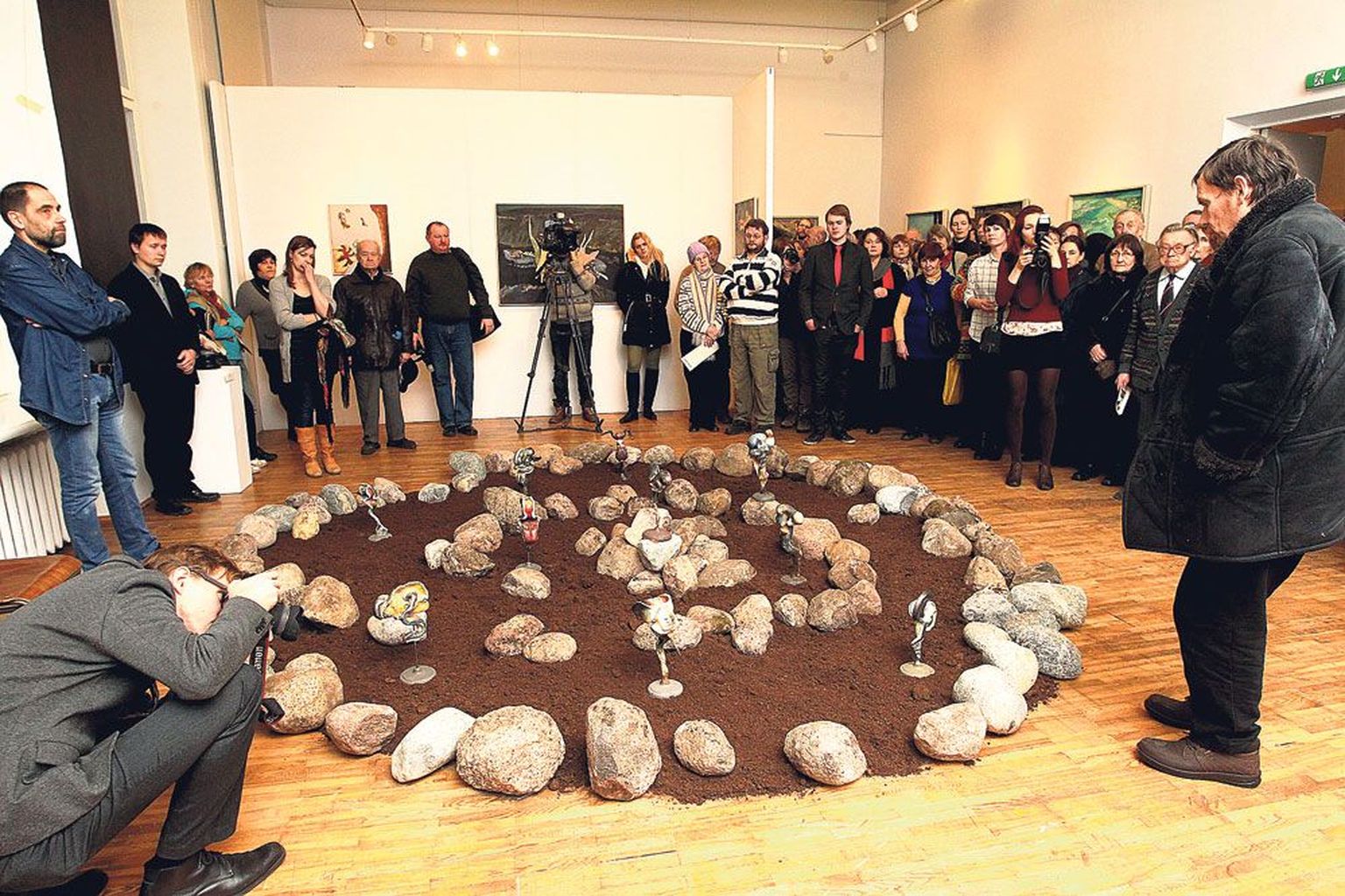 Näituse avamisel Tartu kunstimaja suurimas saalis meenutab kunstiajaloolane ja -kriitik Ants Juske (paremal) kunstnik Ilmar Malini installatsiooni «Organon» juures, kuidas ta aitas üles seada sedasama installatsiooni esimesel korral. Teda pildistab kunstimaja galerist Indrek Grigor. Kuulajate hulgas on kunstniku poeg Jaan Malin (vasakul esimene).