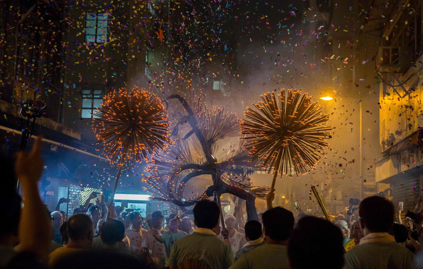 TOPSHOT - This picture taken on September 14, 2016 shows members of the fire dragon dance team holding up the 'dragon' as it winds through the narrow streets and houses during the Tai Hang Fire Dragon Dance in Hong Kong.
The century-long tradition involves waving incense-lit, straw-filled dragons to bring blessings to onlookers under the full moon during the annual Mid-Autumn Festival. / AFP PHOTO / ISAAC LAWRENCE