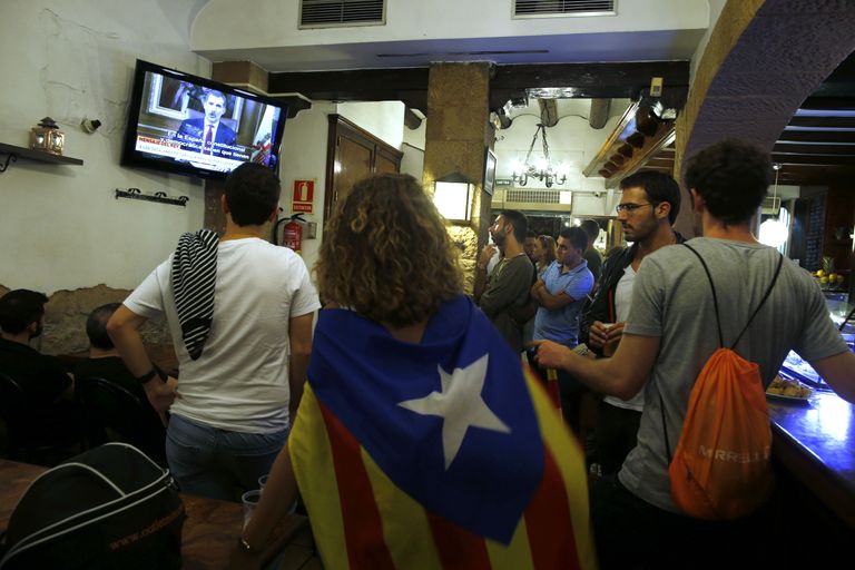 Inimesed, ühel neist Kataloonia rahvuslipp õlgadel, vaatamas Hispaania kuninga Felipe VI telepöördumist Kataloonia iseseisvusreferendumi teemal / Scanpix