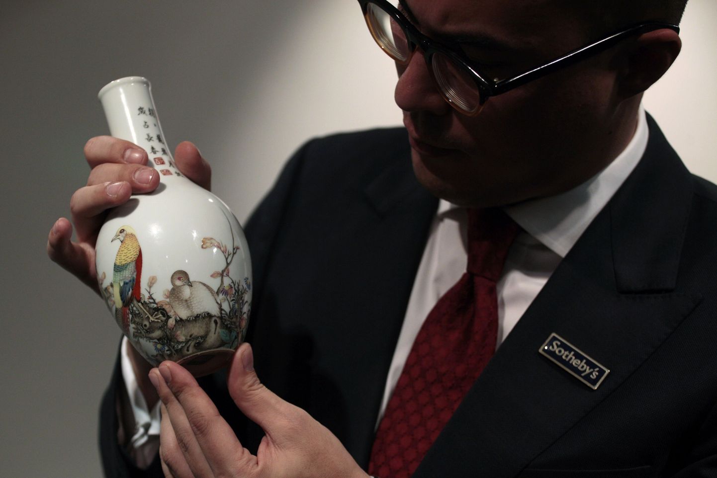 Sotheby's oskjonimaja esindaja Nicolas Chow koos kallihinnalise vaasiga