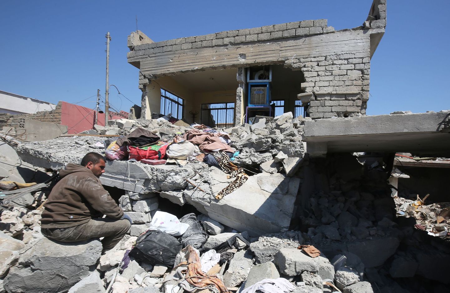 Mees Mosuli linnas oma maja varemete juures.