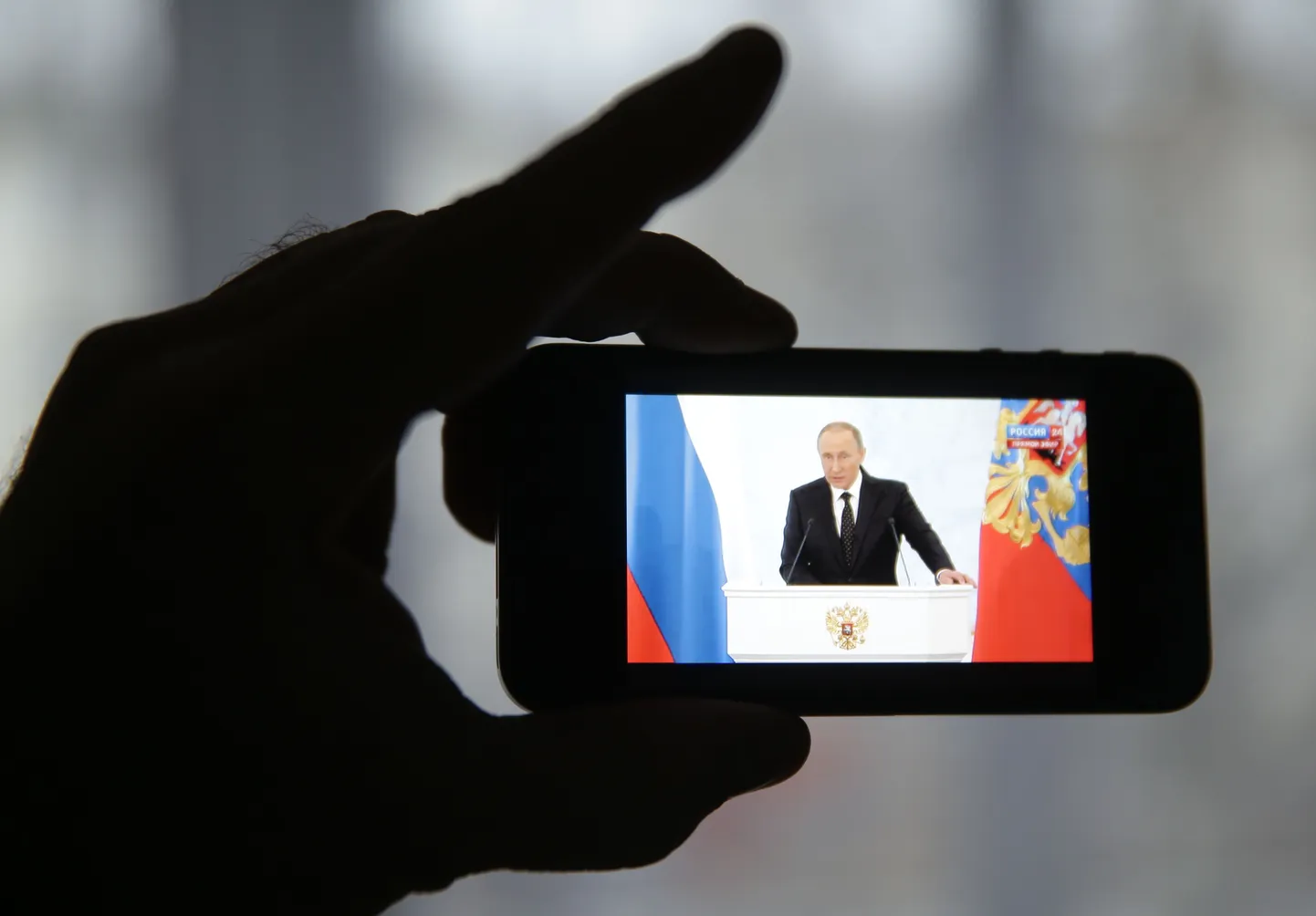 Kodanik vaatab Vladimir Putini esinemist nutiseadmega.