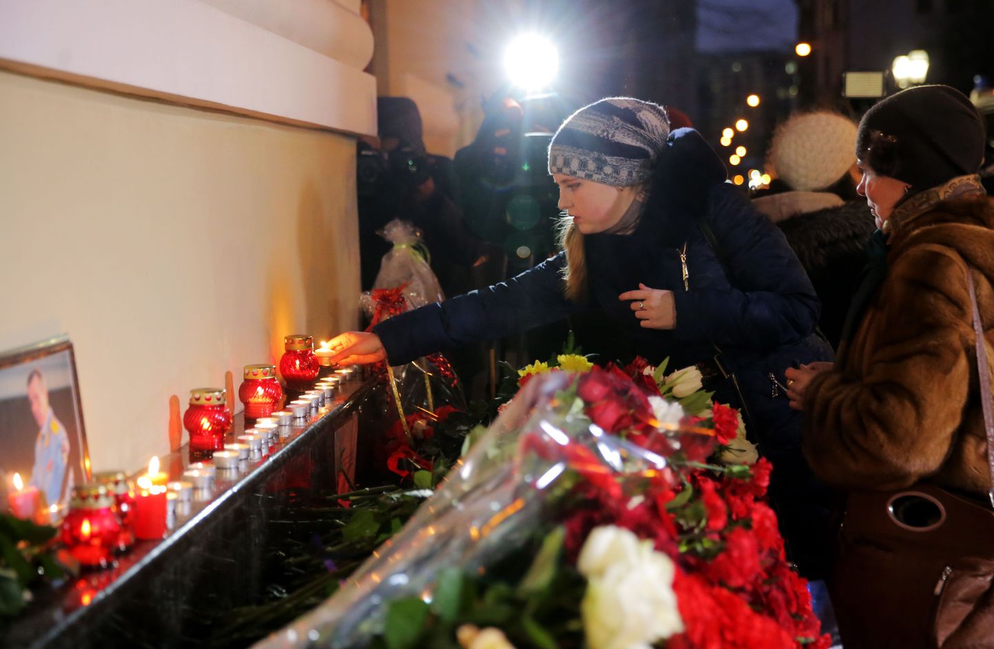 Люди несут цветы к концертному залу "Александровский" в Москве в память о жертвах авиакатастрофы.