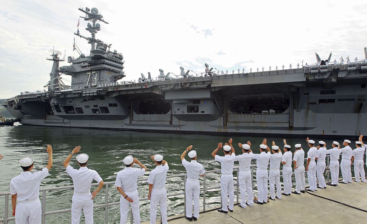 Южнокорейские моряки приветствуют американцев на военных маневрах.