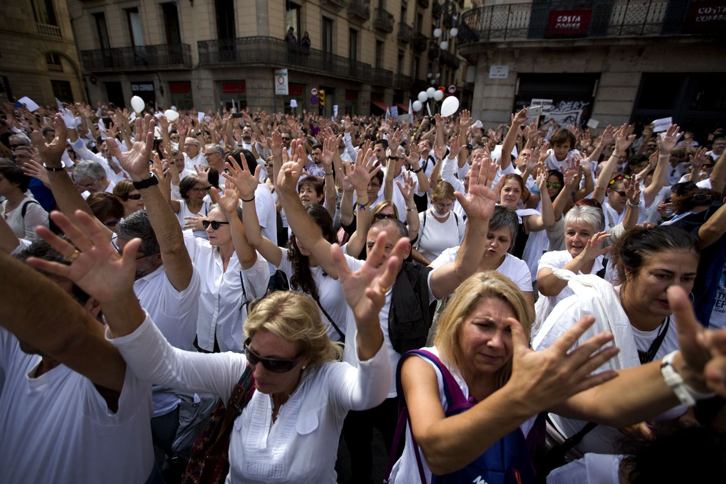 People raise their hands during a protest in favor of talks and dialogue in Sant Jaume square in Barcelona, Spain, Saturday Oct. 7, 2017. Thousands gathered at simultaneous rallies in Madrid and Barcelona in a call for dialogue amid a political crisis caused by Catalonia's secession push. (AP Photo/Emilio Morenatti)